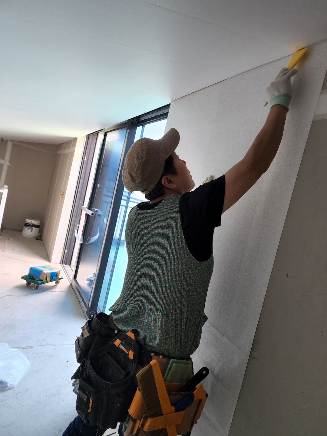 Professional interior contractor applying wallpaper with precision